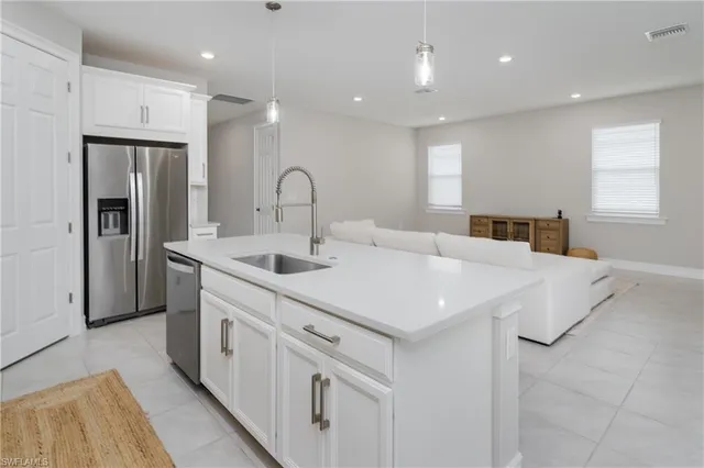 a kitchen with stainless steel appliances a sink a stove a refrigerator and cabinets