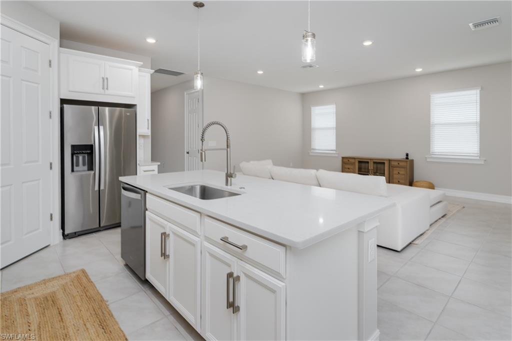 14643 Stillwater Way Naples, FL 34114 - Photo 9 of 50 a kitchen with stainless steel appliances a sink a stove a refrigerator and cabinets
