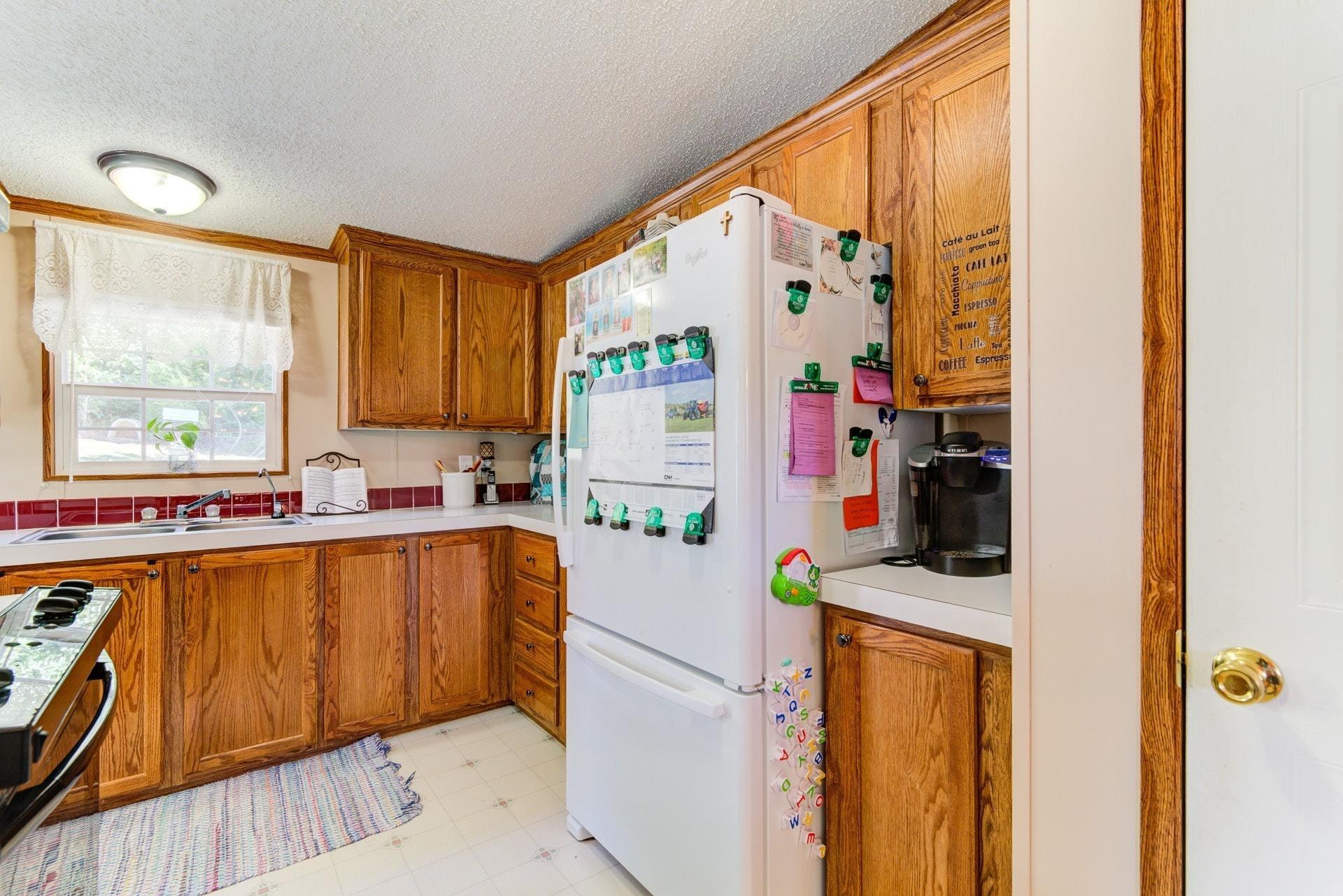 1383 6 Mile Post Road Callaway, VA 24067 - Photo 13 of 30 a kitchen with a refrigerator a stove top oven a sink and a window