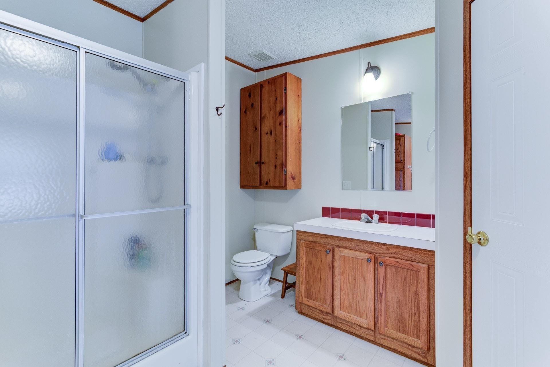 1383 6 Mile Post Road Callaway, VA 24067 - Photo 18 of 30 a bathroom with a toilet sink vanity and mirror