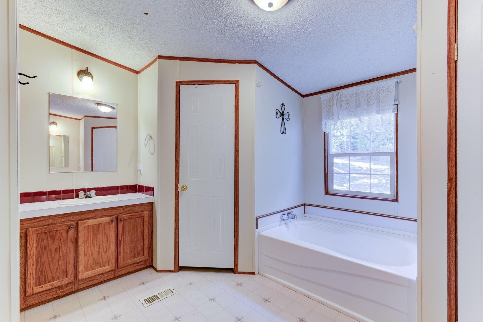 1383 6 Mile Post Road Callaway, VA 24067 - Photo 19 of 30 a bathroom with a tub sink and mirror