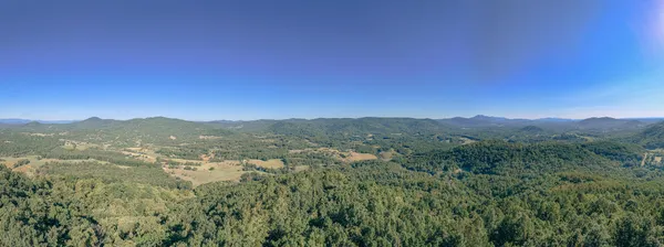 a view of a mountain range with lush green forest