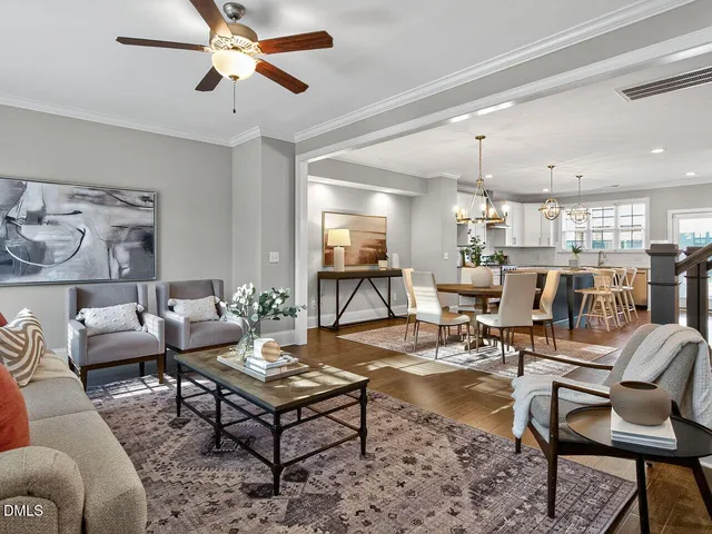a living room with lots of furniture and view of kitchen
