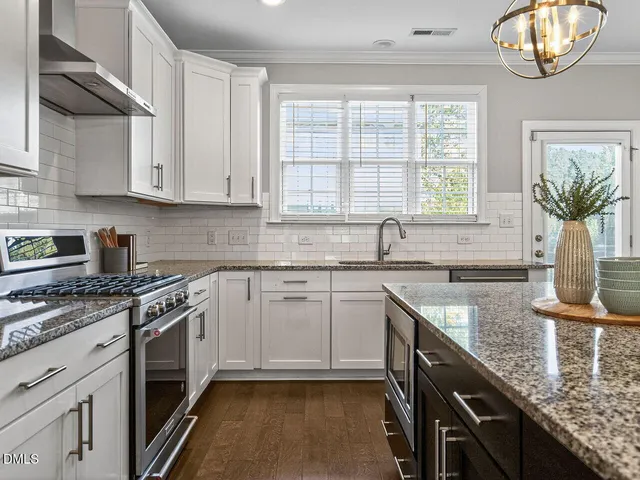 a kitchen with granite countertop a sink a counter space appliances and cabinets