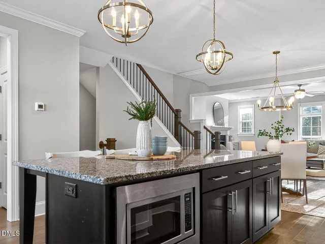 a kitchen with kitchen island granite countertop a sink a stove and a wooden floor