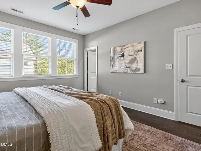 a bedroom with a large bed and a chandelier