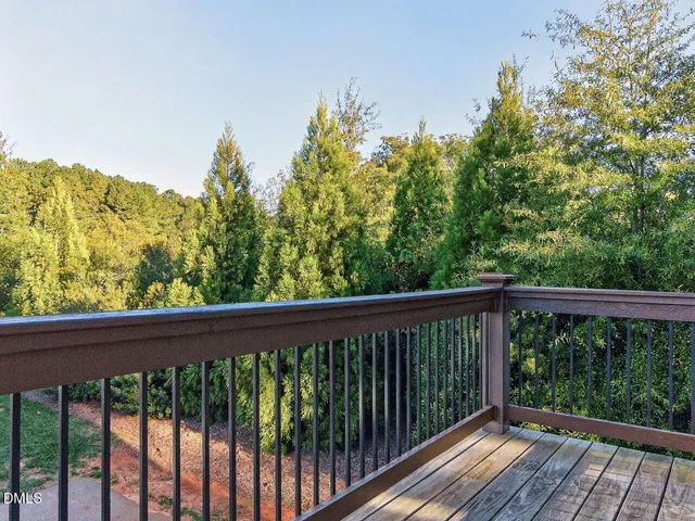 a balcony with wooden floor and yard in the back