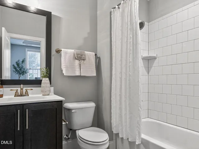 a bathroom with a sink a toilet and shower curtain