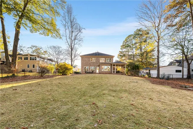 a front view of a house with a yard and large trees