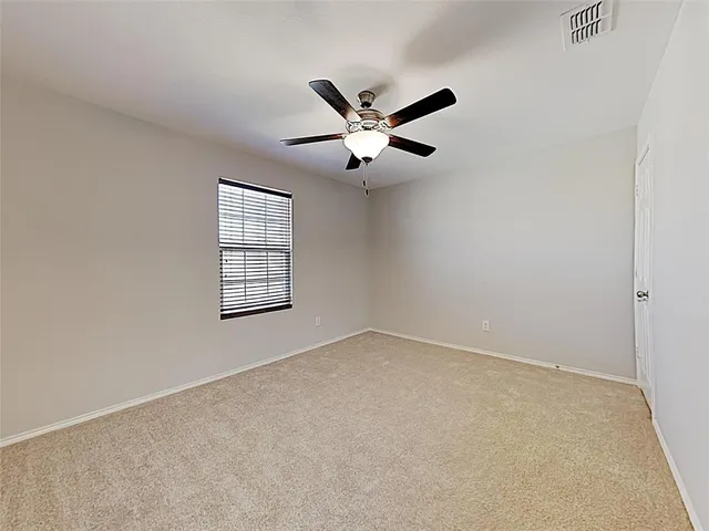 an empty room with a window and a ceiling fan