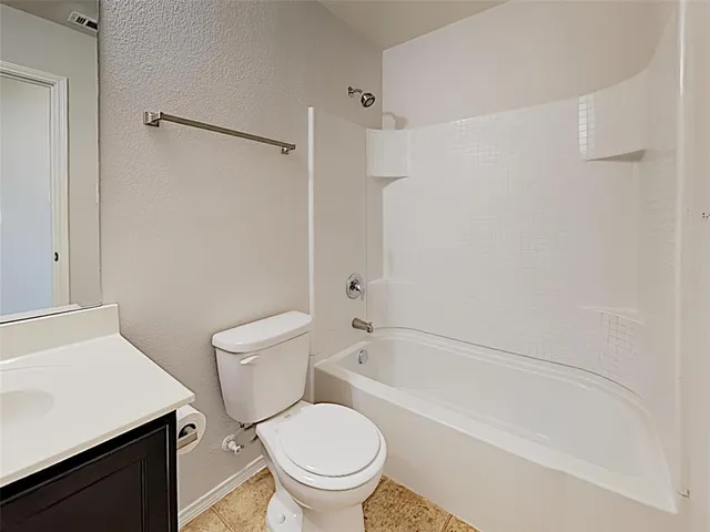 a white toilet sitting next to a bath tub