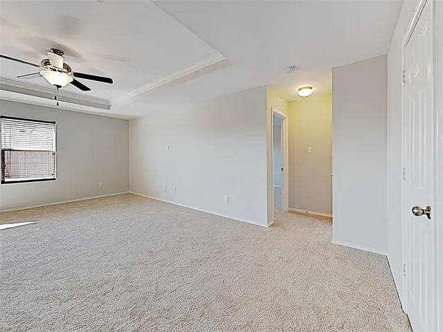 a view of an empty room and a ceiling fan window