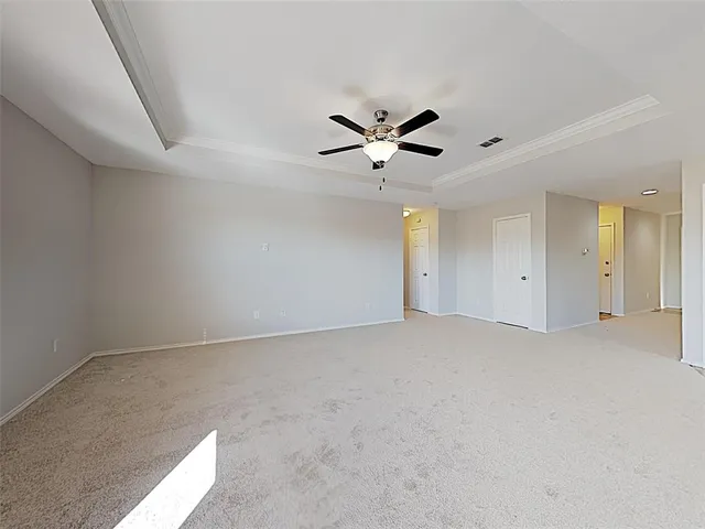 an empty room with a ceiling fan and window