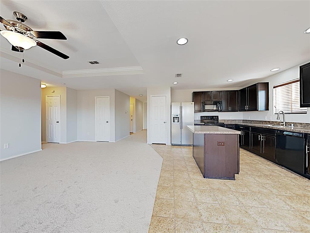 1620 Gayla Creek Drive Little Elm, TX 75068 - Photo 5 of 13 a large kitchen with stainless steel appliances kitchen island granite countertop a stove top oven a sink a refrigerator and cabinets