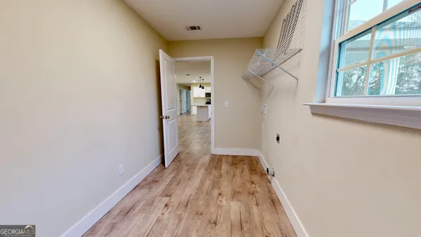 a view of a room with wooden floor staircase and a hallway