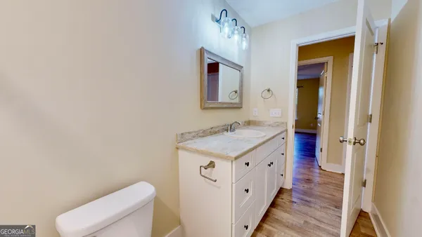 a spacious bathroom with a granite countertop sink and a toilet