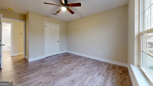 an empty room with wooden floor and windows