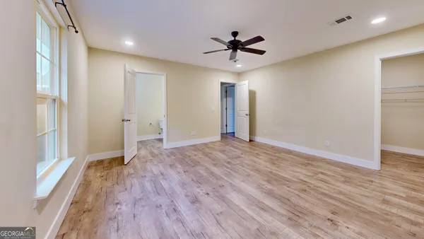 a view of empty room with wooden floor and window