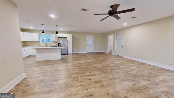 a view of kitchen with microwave oven stove and white cabinets