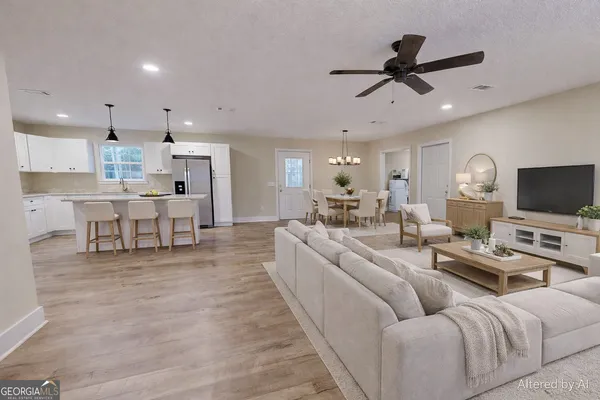 a living room with furniture and a flat screen tv with kitchen view