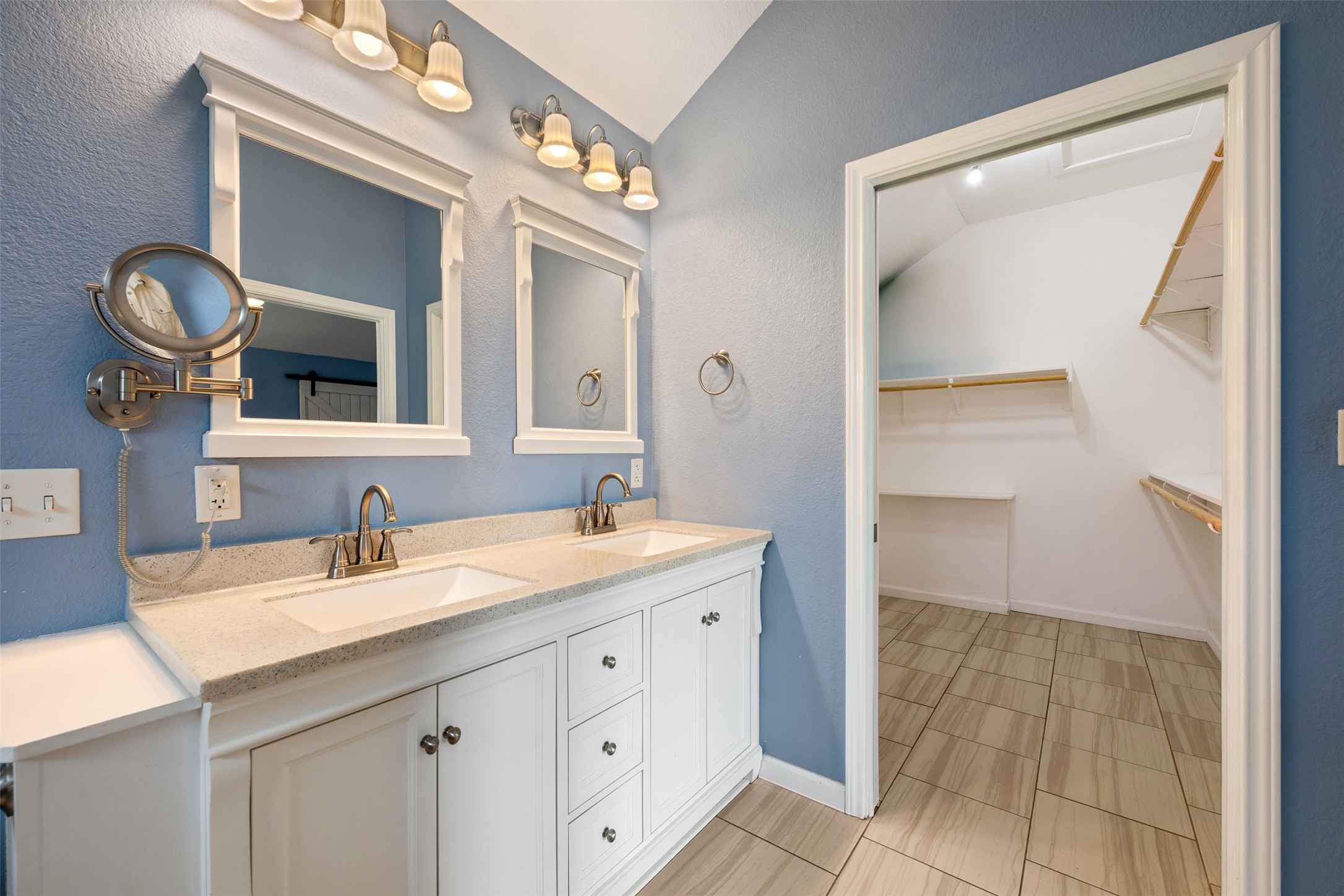 104 Sunset Road Georgetown, TX 78633 - Photo 23 of 40 Full bathroom featuring double vanity, a spacious closet, a textured wall, and lofted ceiling
