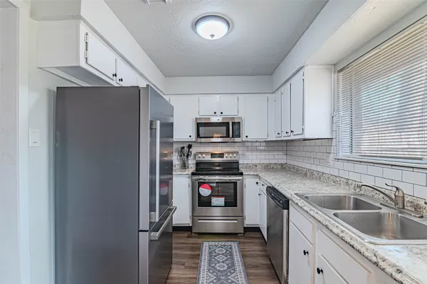 a kitchen with granite countertop a refrigerator and a sink