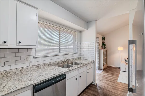 a kitchen with granite countertop a sink and a window