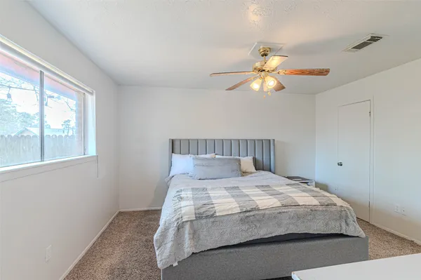 a bedroom with a bed and a chandelier fan
