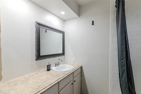 a bathroom with a granite countertop sink and a mirror