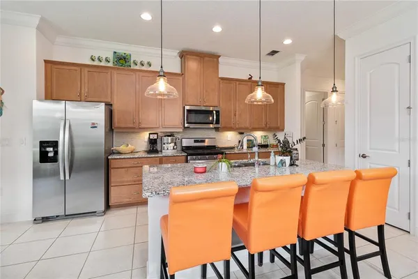 a kitchen with stainless steel appliances granite countertop a stove a refrigerator a oven a sink with a dining table and chairs