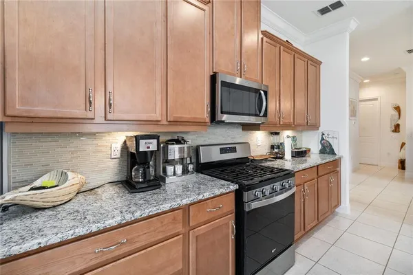 a kitchen with granite countertop a sink a stove and cabinets