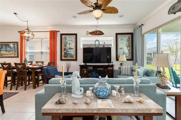 a living room with furniture kitchen view and a large window