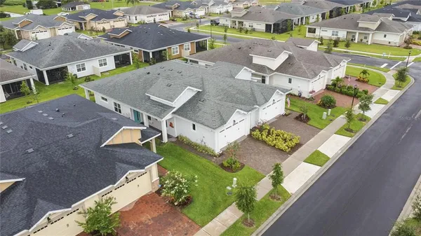 an aerial view of a house with a yard and outdoor seating