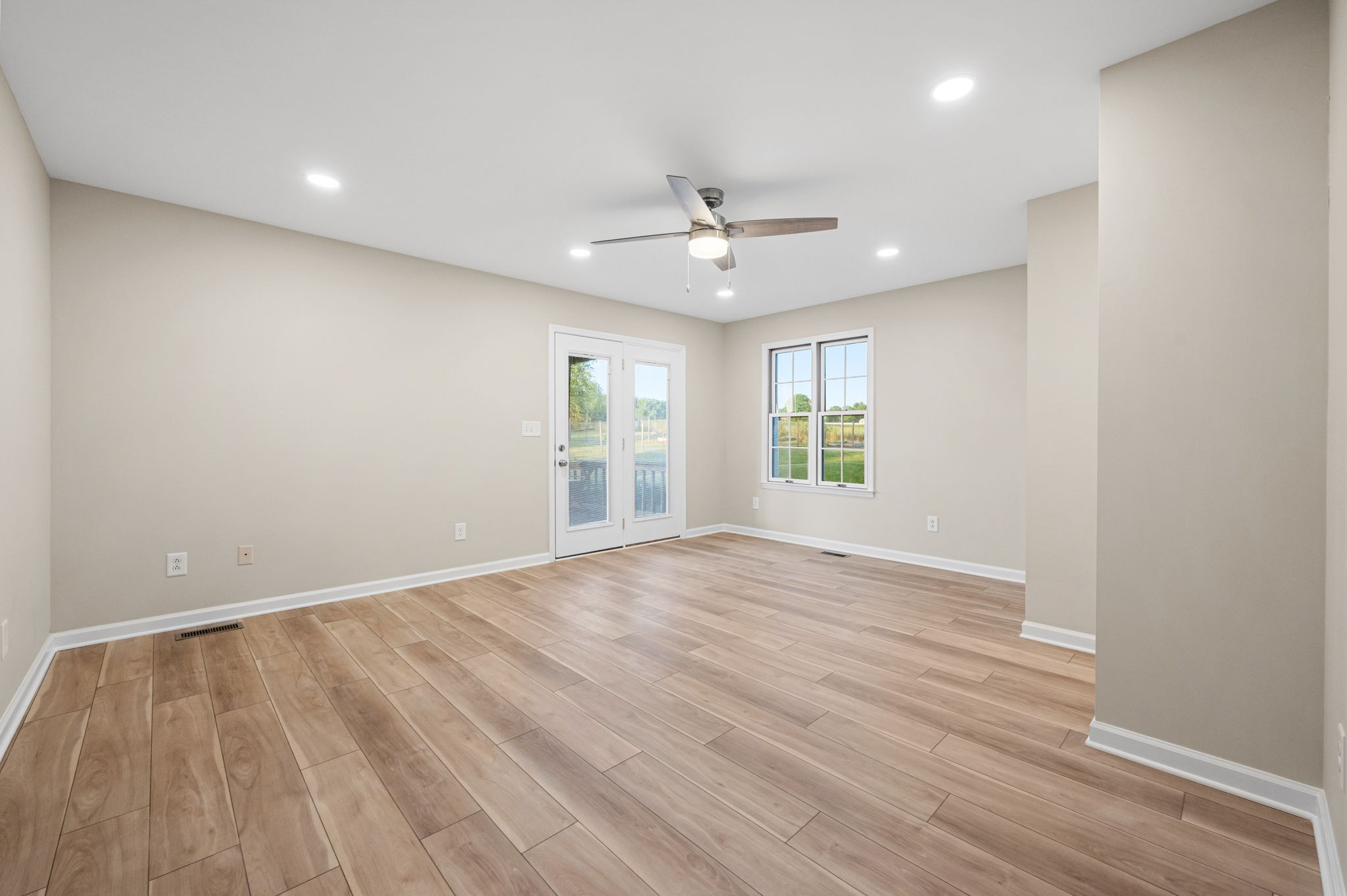205 Normandy Road Wartrace, TN 37183 - Photo 29 of 70 an empty room with wooden floor ceiling fan and windows