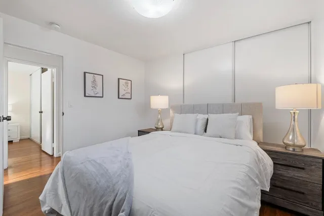 a bedroom with a bed and wooden floor