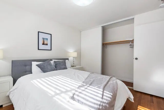 a bedroom with a bed and wooden floor