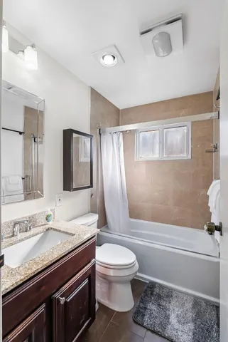 a bathroom with a granite countertop sink toilet and shower