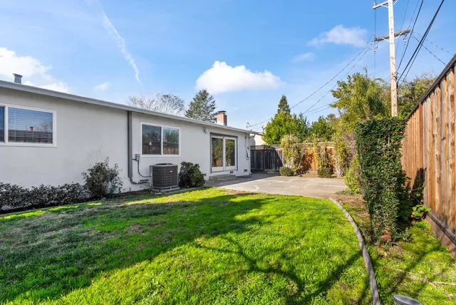 a view of a house with a big yard and potted plants