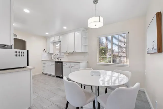 a kitchen with a dining table chairs and refrigerator