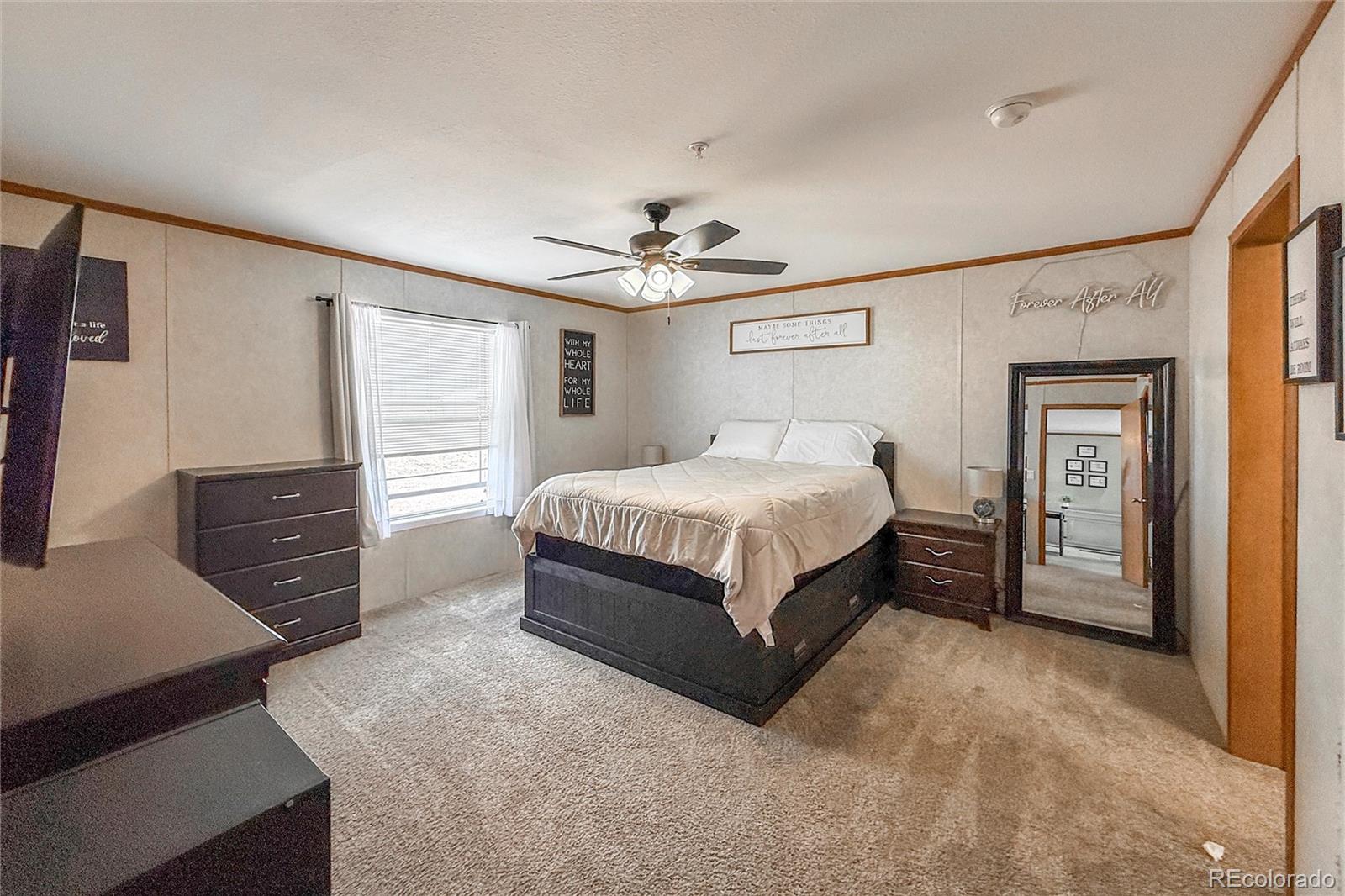 16412 Higgins Avenue Fort Lupton, CO 80621 - Photo 13 of 27 a bedroom with a bed and a chandelier