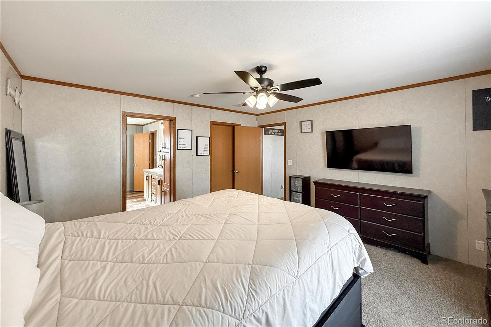 16412 Higgins Avenue Fort Lupton, CO 80621 - Photo 14 of 27 a bedroom with a bed and a flat screen tv