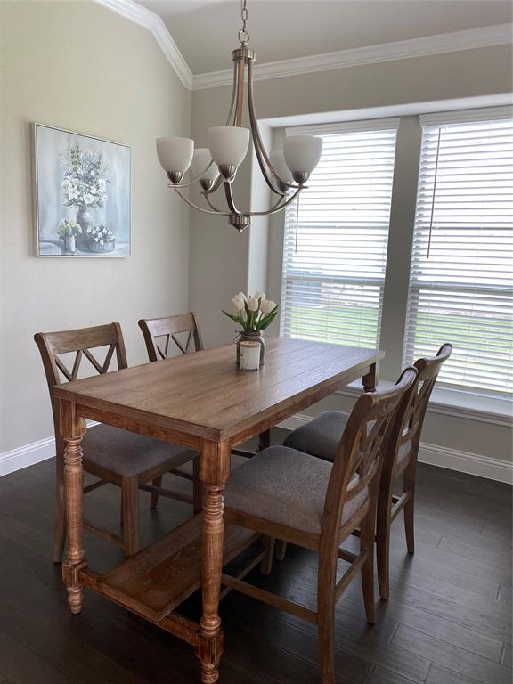 209 Johnson Street Granbury, TX 76048 - Photo 18 of 40 Dining area featuring ornamental molding, a notable chandelier, and dark wood-type flooring