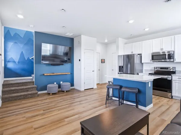 a kitchen with stainless steel appliances kitchen island granite countertop a stove a sink a refrigerator and a microwave