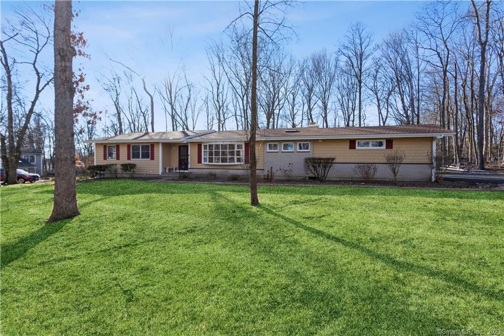 a view of house with a backyard