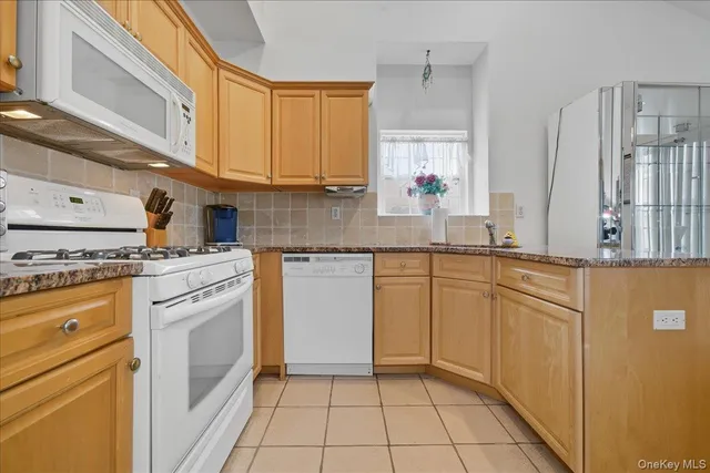 a kitchen with granite countertop white cabinets and white appliances