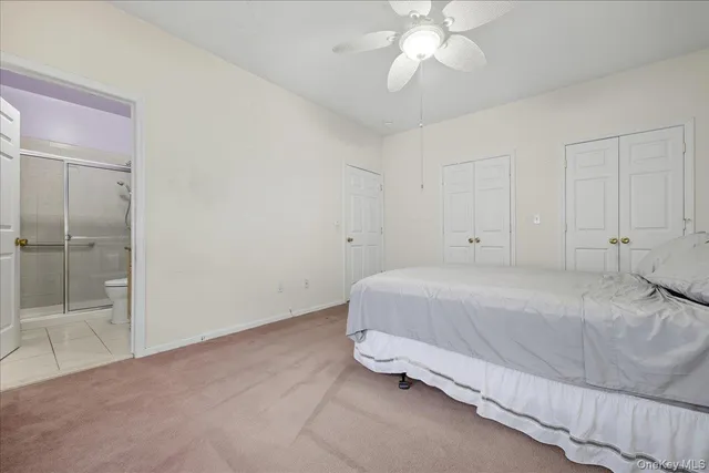 a spacious bedroom with a bed and a chandelier