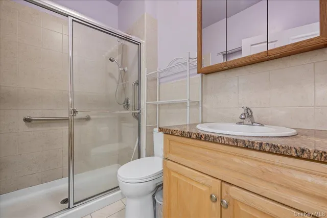 a bathroom with a granite countertop sink a toilet and shower