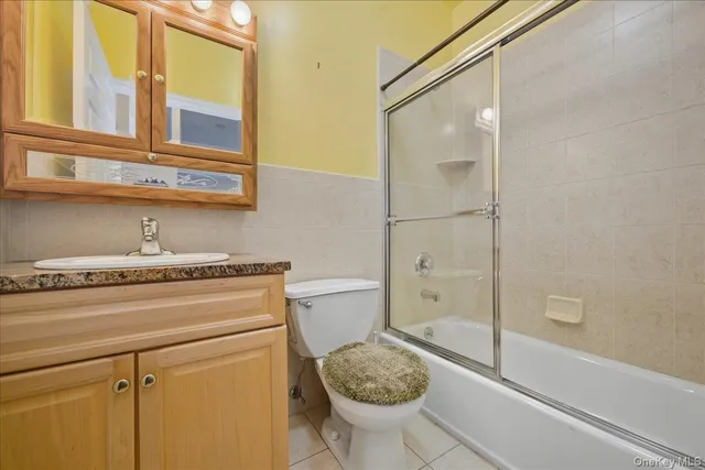 a bathroom with a granite countertop sink a toilet and shower