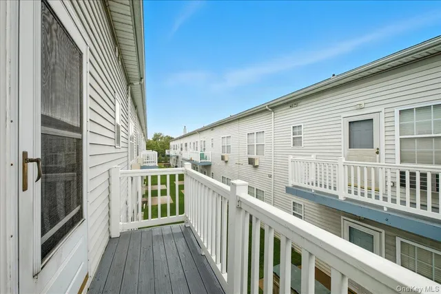 a view of a balcony with wooden floor and fence