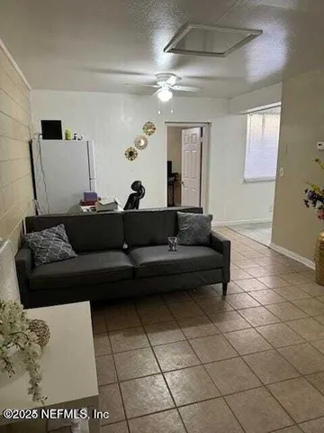 a living room with a couch and a potted plant